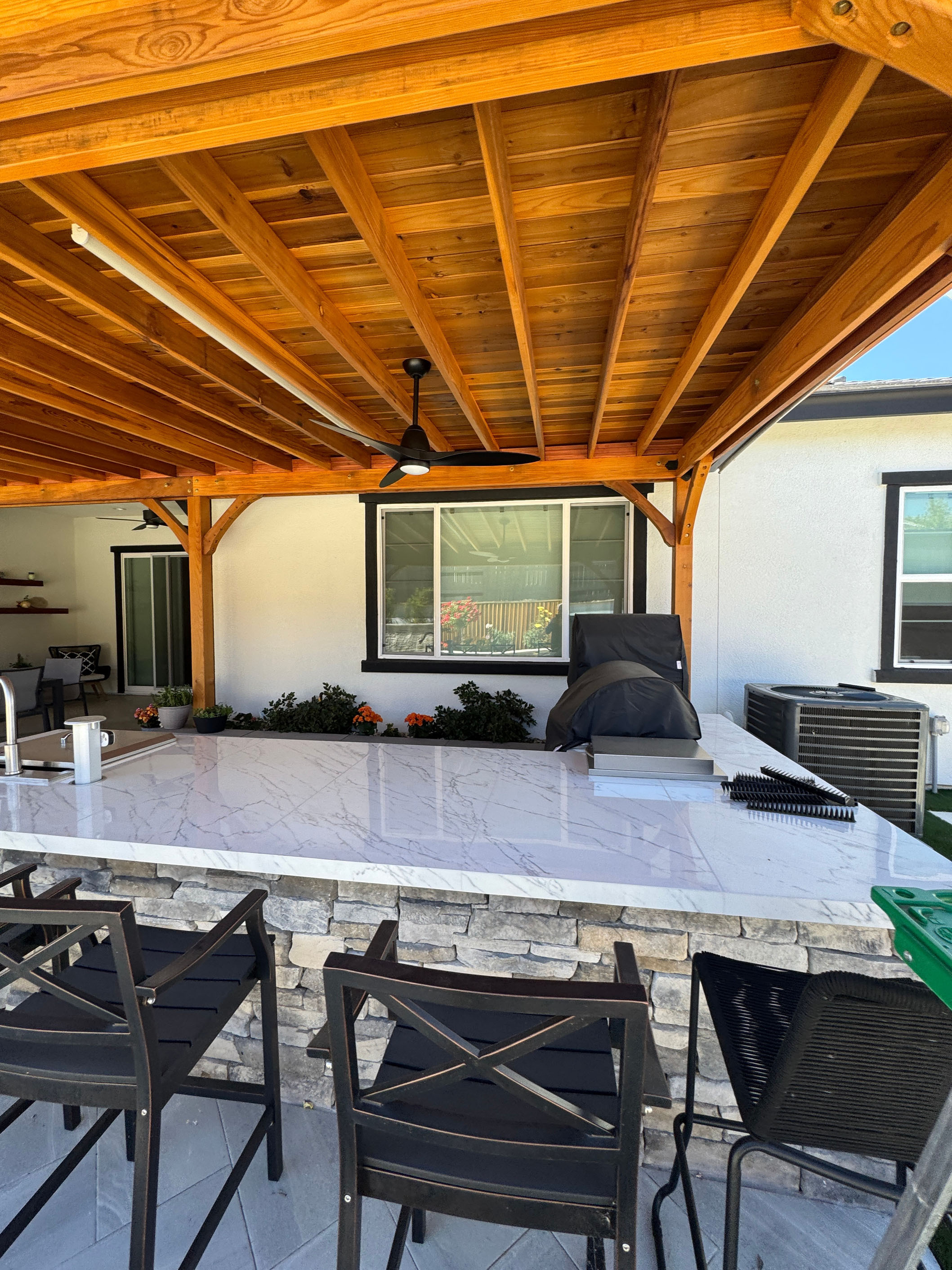 Outdoor kitchen with stainless appliances and bar seating